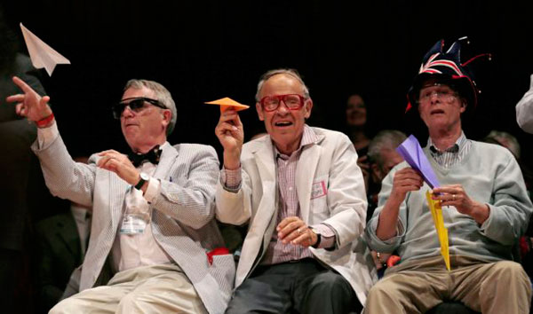 Nobel laureates Robert Kirshner, Dudley Herschbach, and Rich Roberts, from left, fire paper airplanes back at the audience during the Ig Nobel Prize ceremony